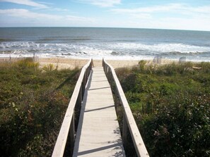 A wooden boardwalk leading to a beach with waves crashing onto the shore. - Oceanfront House on the beach at Croatan (Virginia Beach)