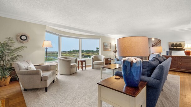 A spacious living room with a large window, a blue vase, and a wooden coffee table. - OCEAN FRONT: PACIFIC HAVEN:  On the Prom: Seaside Vacation Homes, Inc Managed  (Seaside)