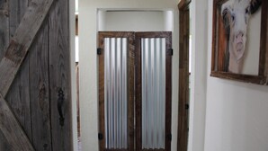A hallway with wooden doors and a metal-framed window. - Come Live on the farm  (Starke)