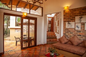 A cozy living area with a brick wall, a sofa, and a dining table.