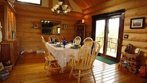 A wooden dining room with a table set for four, surrounded by wooden chairs. - Gray's room Garrison Inn Montana bed and breakfast (Kalispell)
