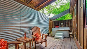 A wooden deck with a chair, a table, and a hot tub.