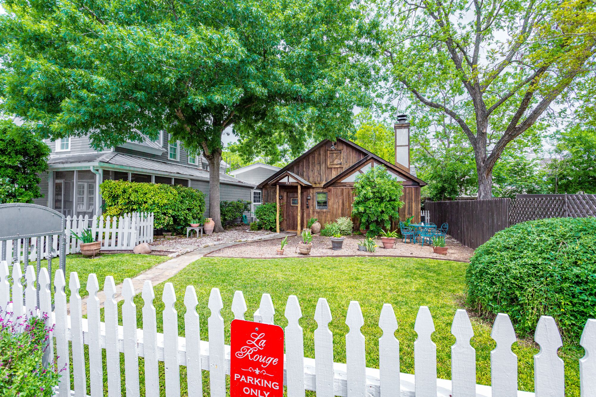 A residential property with a fenced yard, a wooden house, and a sign indicating parking is only for the residence.