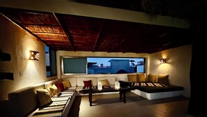 A modern living room with a sofa set, a coffee table, and a view of the sea.