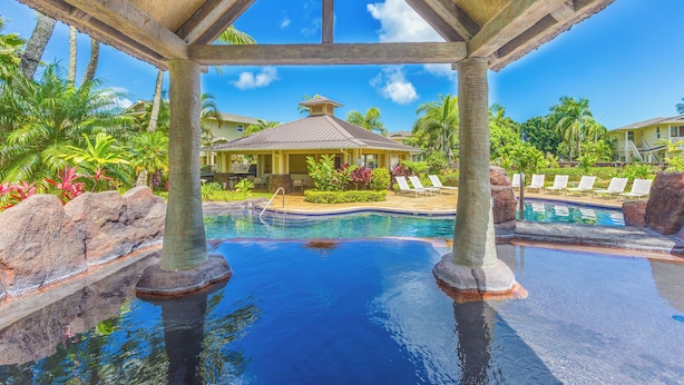 A pool area with lounge chairs and a gazebo.