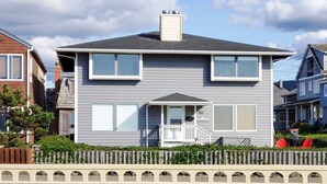 A two-story house with a front porch, a chimney, and a mailbox. - OCEAN FRONT: BEACHTOPIA South:  Seaside Vacation Homes, Inc Managed  (Seaside)