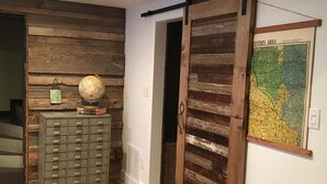 A room with a wooden wall, a globe, a chest of drawers, a sliding door, and a map on the wall. - On the river,Close to Midtown,Fun Trackers, The Inn , Fishing. Sleeps 11 in bed (Ruidoso)