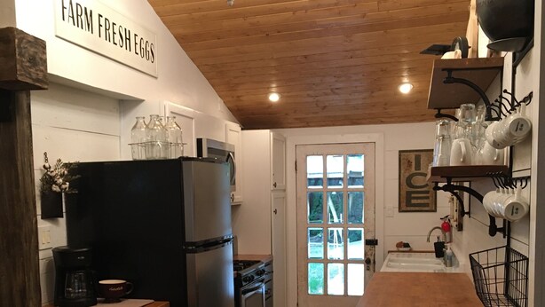A kitchen with a refrigerator, stove, and coffee maker. There is a sign that reads "FARM FRESH EGGS" on the wall. - On the river,Close to Midtown,Fun Trackers, The Inn , Fishing. Sleeps 11 in bed (Ruidoso)