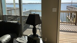 A room with a view of a waterfront, a wooden deck, and a chair. - The CLOSEST, PRIVATE, LIT, 50 FT. FISHING PIER to the Gulf of Mex, w boat slips (Corpus Christi)