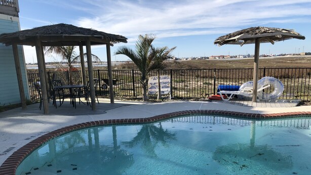 A swimming pool with a brick edge and a sign indicating its depth. - The CLOSEST, PRIVATE, LIT, 50 FT. FISHING PIER to the Gulf of Mex, w boat slips (Corpus Christi)