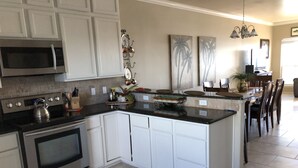 A modern kitchen with white cabinets, stainless steel appliances, and a central island. - The CLOSEST, PRIVATE, LIT, 50 FT. FISHING PIER to the Gulf of Mex, w boat slips (Corpus Christi)