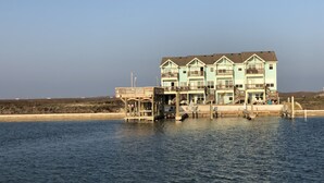 A multi-story waterfront building with balconies, a dock, and a pier. - The CLOSEST, PRIVATE, LIT, 50 FT. FISHING PIER to the Gulf of Mex, w boat slips (Corpus Christi)
