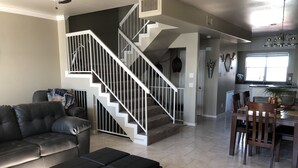 A living room with a staircase, a dining area, and a kitchen. - The CLOSEST, PRIVATE, LIT, 50 FT. FISHING PIER to the Gulf of Mex, w boat slips (Corpus Christi)