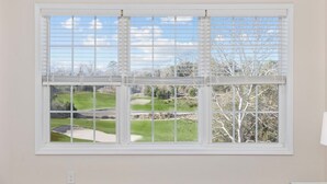 A window with a view of a golf course. - Luxury Golf-View Condo • Barefoot Resort • Resort Pools • Premium Beach Gear (North Myrtle Beach)