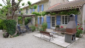 A courtyard with a stone bench, a table, and a pizza oven. There are potted plants and a tree. - Country Villa 'Mas' in the Heart of Provence, 4bed, 4bath with AC (Rognonas)