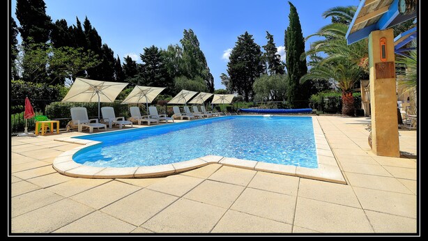 A swimming pool with lounge chairs and umbrellas, surrounded by trees and a clear sky. - Country Villa 'Mas' in the Heart of Provence, 4bed, 4bath with AC (Rognonas)
