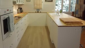 A compact kitchen with white cabinetry, a built-in oven, and a wooden countertop. - Country Villa 'Mas' in the Heart of Provence, 4bed, 4bath with AC (Rognonas)