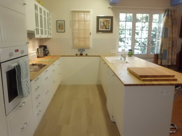 A compact kitchen with white cabinetry, a built-in oven, and a wooden countertop. - Country Villa 'Mas' in the Heart of Provence, 4bed, 4bath with AC (Rognonas)