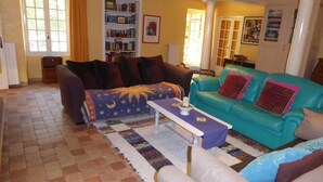A living room with a sofa, armchairs, a coffee table, a bookshelf, and a patterned rug. - Country Villa 'Mas' in the Heart of Provence, 4bed, 4bath with AC (Rognonas)
