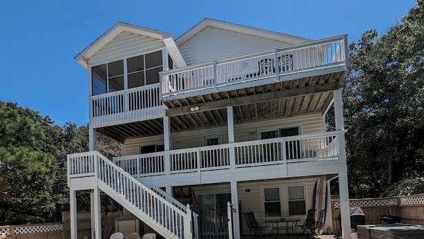 Une maison à deux étages avec une piscine en premier plan.