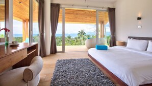 A modern hotel room with a large bed, a wooden desk, and a view of the outdoors. - Villa Monsoon 7-Bedroom with Breathtaking Panoramic Seaview (Amphoe Ko Samui)