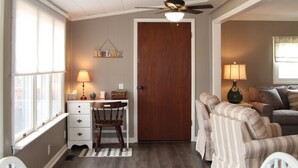 A cozy living room with a dining table, chairs, a sofa, and a ceiling fan. - WOLCOTT NY  Waterfront cottage rental on Port Bay seasonal available 2026 (Port Bay - Wolcott)