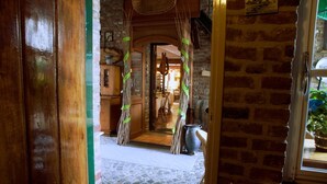 Un intérieur rustique avec un sol en pierre, des poutres en bois et un mur en briques.