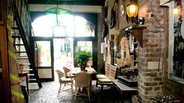 Un intérieur chaleureux et rustique, avec un mur en briques, des meubles en bois et un luminaire suspendu.