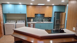 Een moderne keuken met een centraal eiland, barstoelen en inbouwapparatuur.