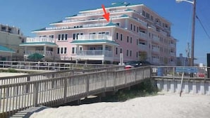 Een meerlaags hotel met balkons, nabij een strand.