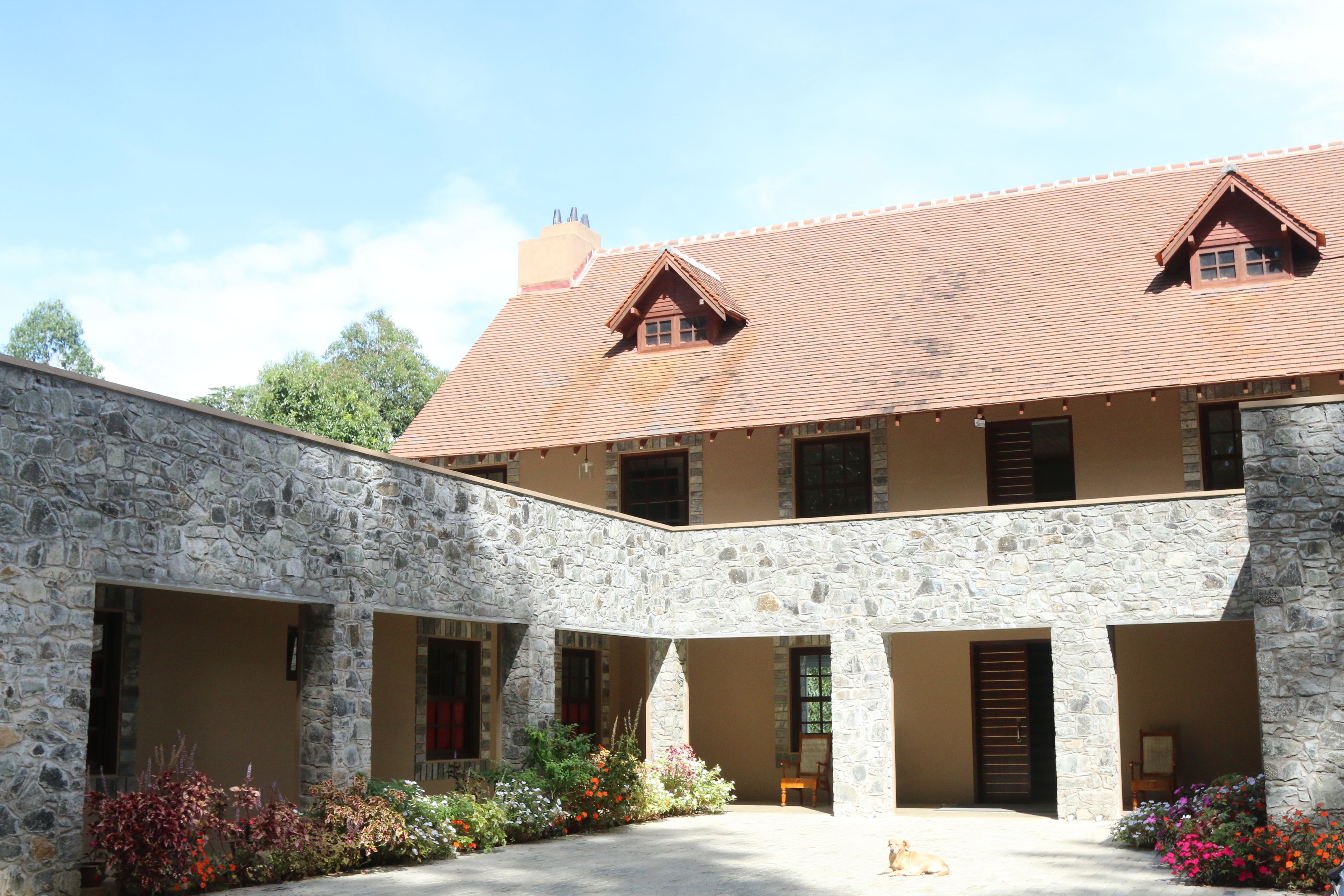 A stone building with a courtyard, multiple windows, and a tiled roof.