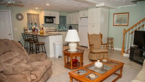 A living room with a brown sofa, a glass coffee table, a wooden side table, a lamp, and a television. - less than a mile from RWU, walking distance to downtown  historic Bristol (Bristol)