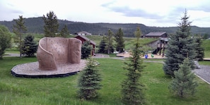 Ein Spielplatz mit Klettergerüsten und einer Rutsche, umgeben von Bäumen und Häusern in Meadow Village.