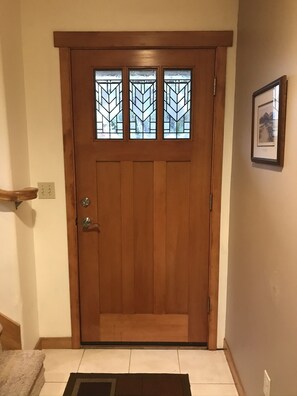 A wooden front door with a glass panel and a small window above it.