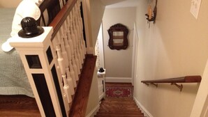 A wooden staircase with a white handrail and a dark balustrade.