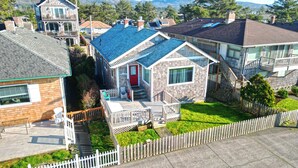 A residential area with houses featuring various roof styles and a well-maintained lawn. - OCEAN FRONT: ONCE UPON A TIDE:  Seaside Vacation Homes, Inc Managed  (Seaside)