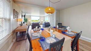 A dining area with a wooden table set for four, surrounded by chairs. - OCEAN FRONT: ONCE UPON A TIDE:  Seaside Vacation Homes, Inc Managed  (Seaside)