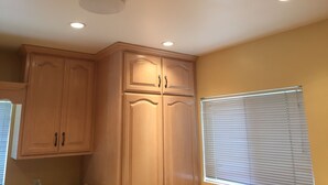 A kitchen with wooden cabinets, a window with blinds, and recessed ceiling lights. - 2BD, 1 BA, BUNGALOW FOR 9 GUESTS!! ENTIRE HOUSE W/ DRIVEWAY PARKING!! (Los Angeles)