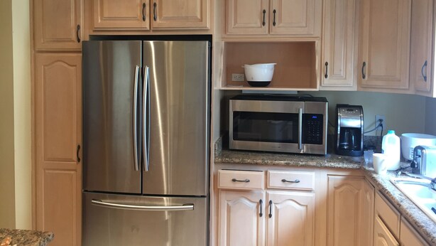 A kitchen with light wooden cabinets, a stainless steel refrigerator, a microwave, and a coffee maker. - 2BD, 1 BA, BUNGALOW FOR 9 GUESTS!! ENTIRE HOUSE W/ DRIVEWAY PARKING!! (Los Angeles)