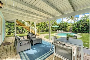 A covered outdoor area with a pool, lounge chairs, and a staircase leading to an upper level. - The Blue Pearl - Soak Up Views from a Scenic Poolside Upper Deck (West Palm Beach)