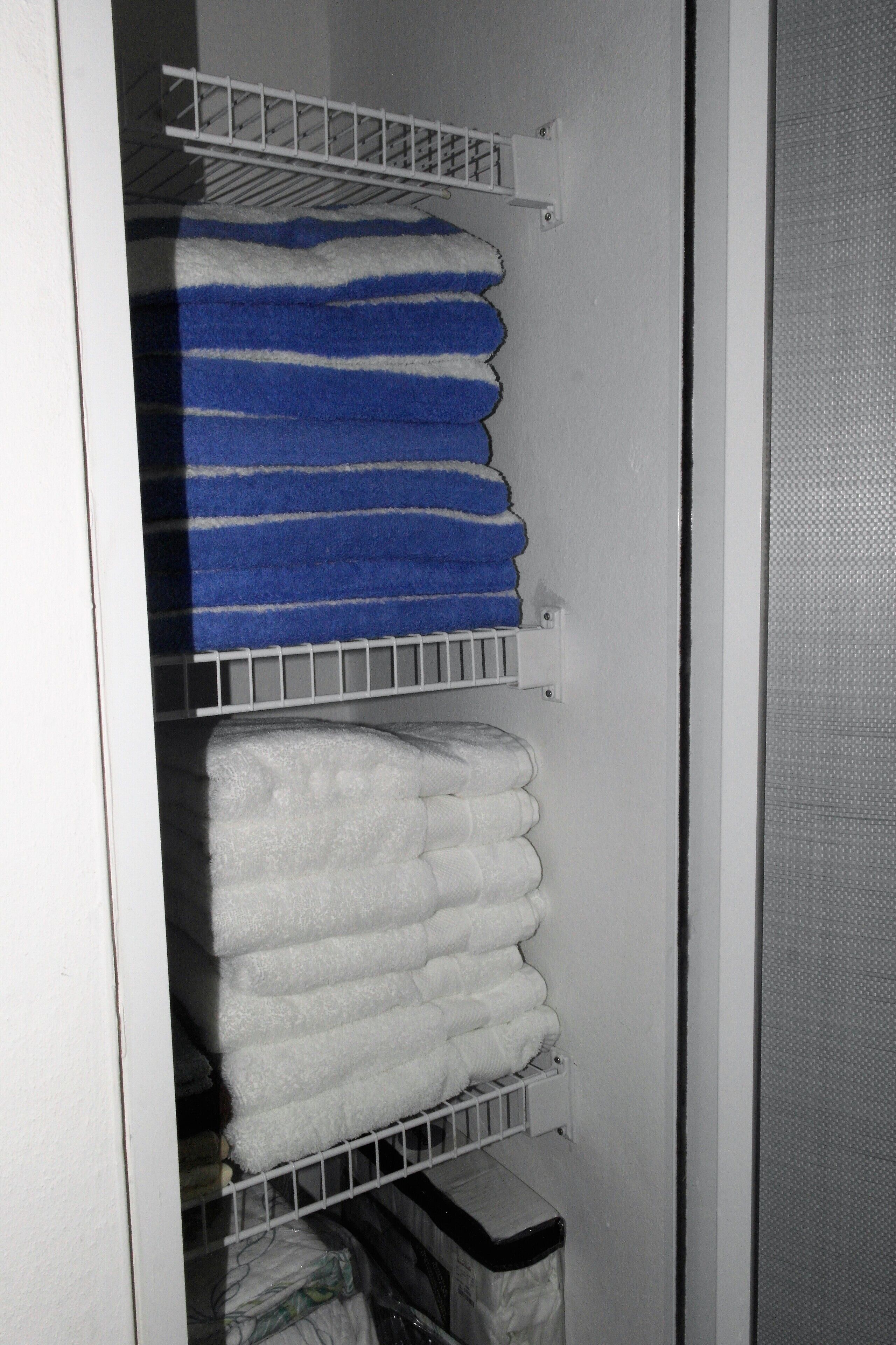 A storage area with shelves holding folded towels in blue and white.