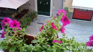 Un balcone con piante e fiori in vaso.