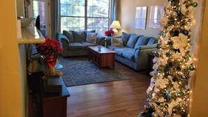 A living room with a sofa, coffee table, and a Christmas tree.