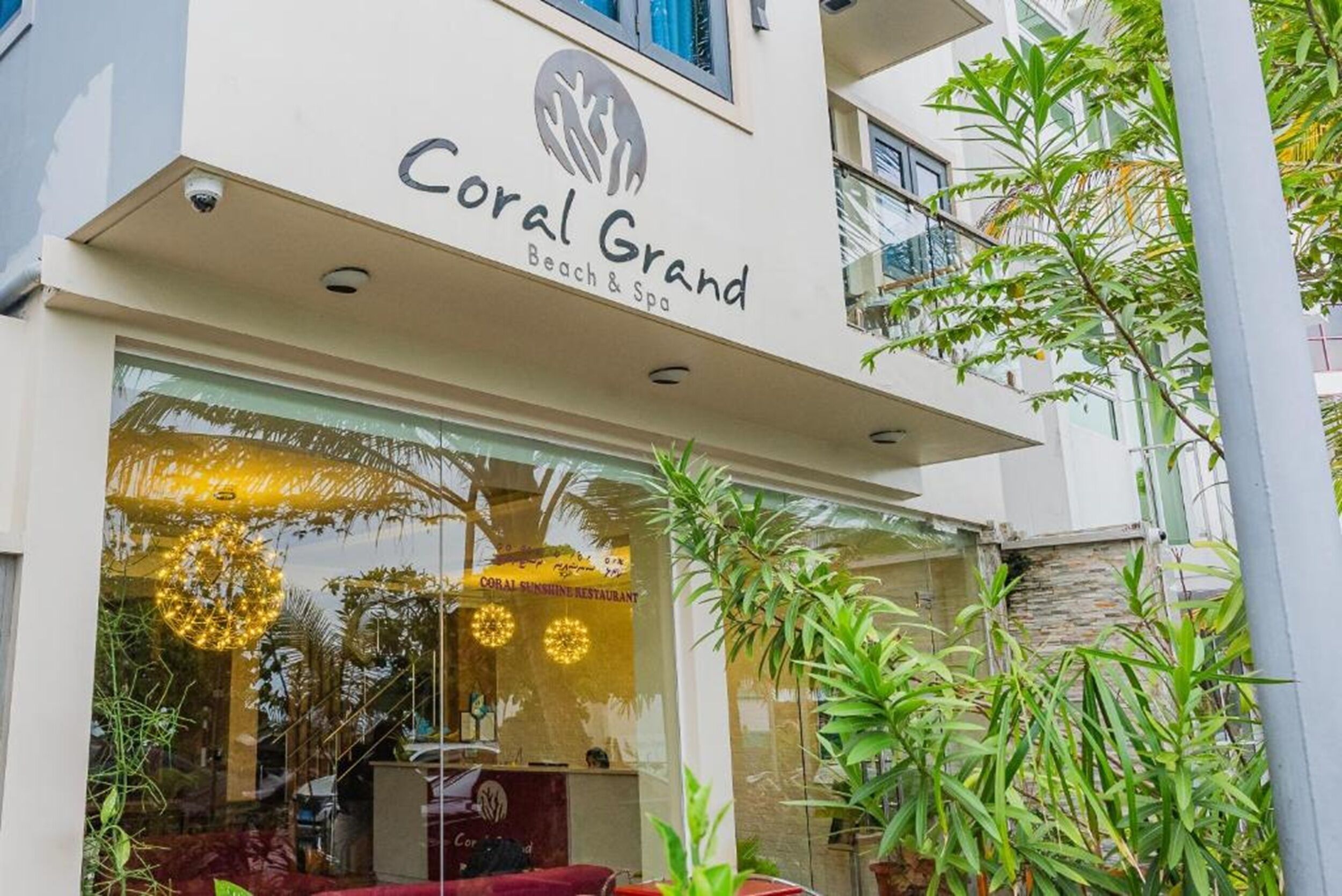 A building with a sign reading 'Coral Grand Beach & Spa.'