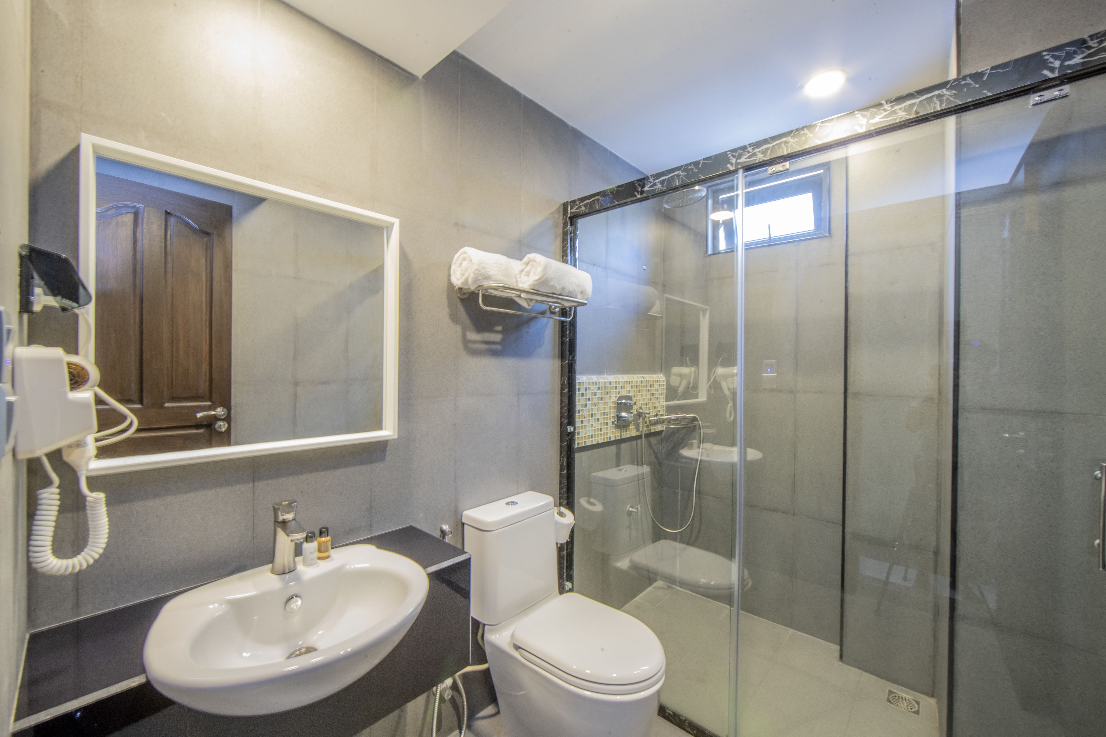 A bathroom with a sink, toilet, and glass-enclosed shower.