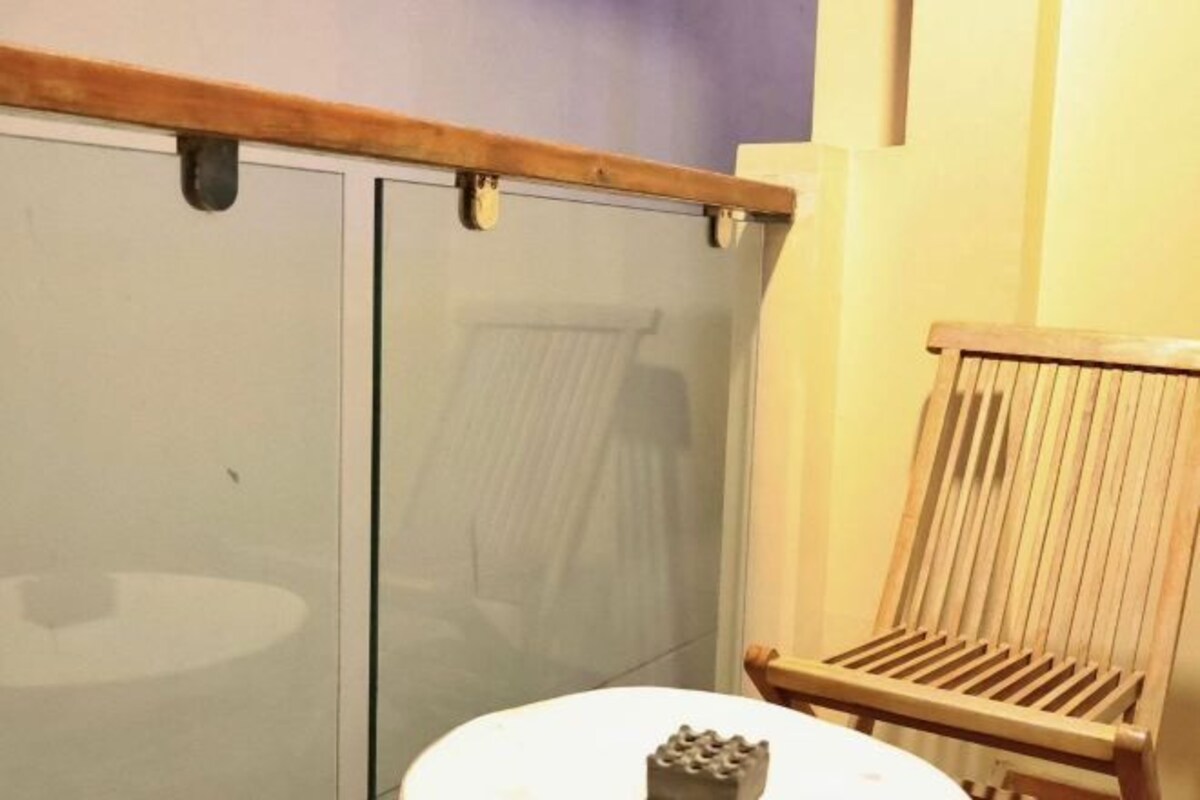A room with a wooden chair, a white table, and a sliding door.