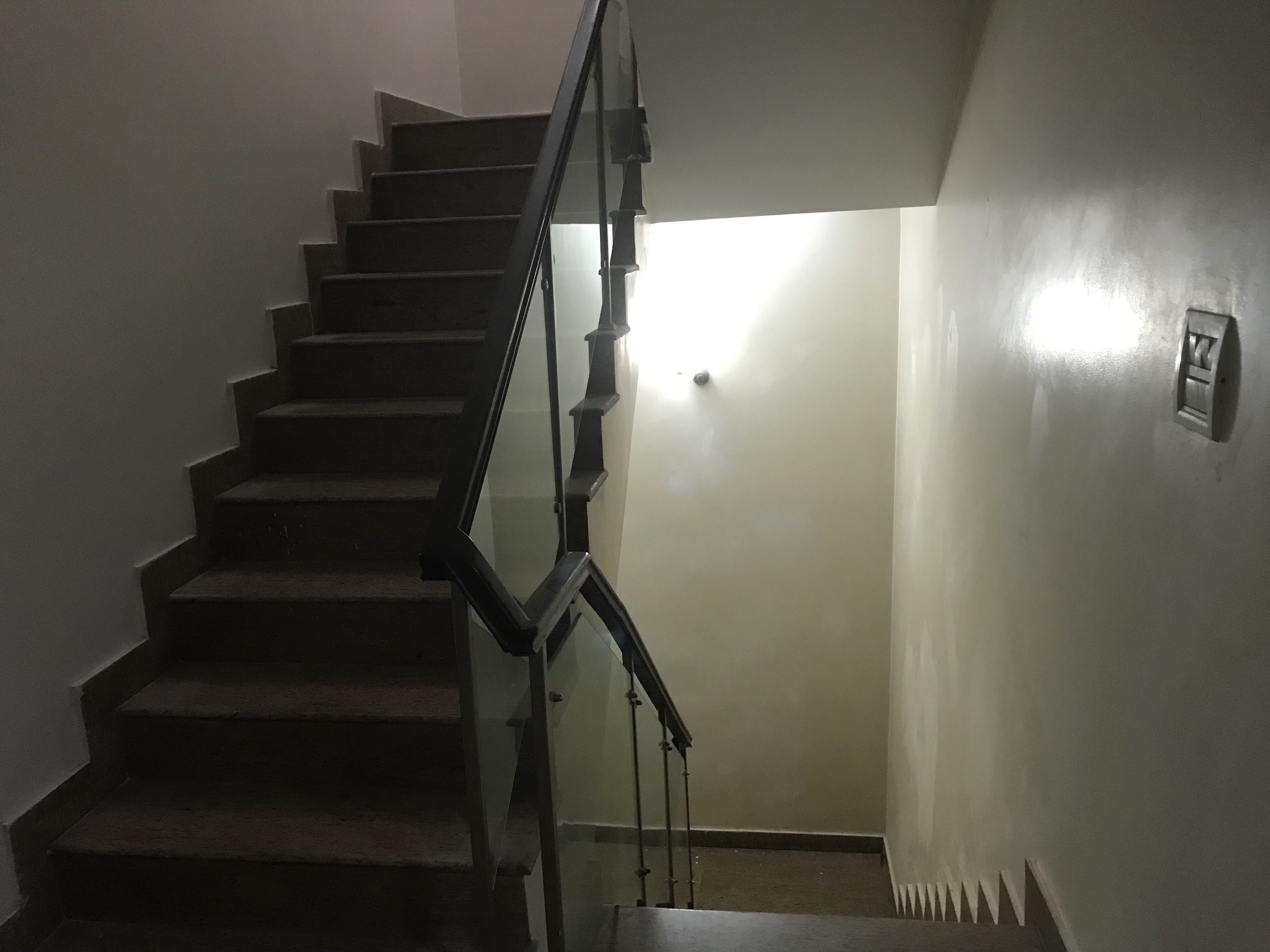 A staircase with a handrail leading to a landing.