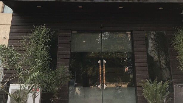 Exterior de l'Hotel Orchid amb un disseny modern, amb un senyal prominent sobre l'entrada i plantes en testos a la façana.