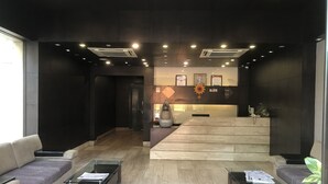Un vestíbul modern amb taulell de recepció, sofàs i una taula de cafè.