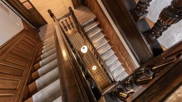 A grand staircase with wooden railings and a checkered carpet.